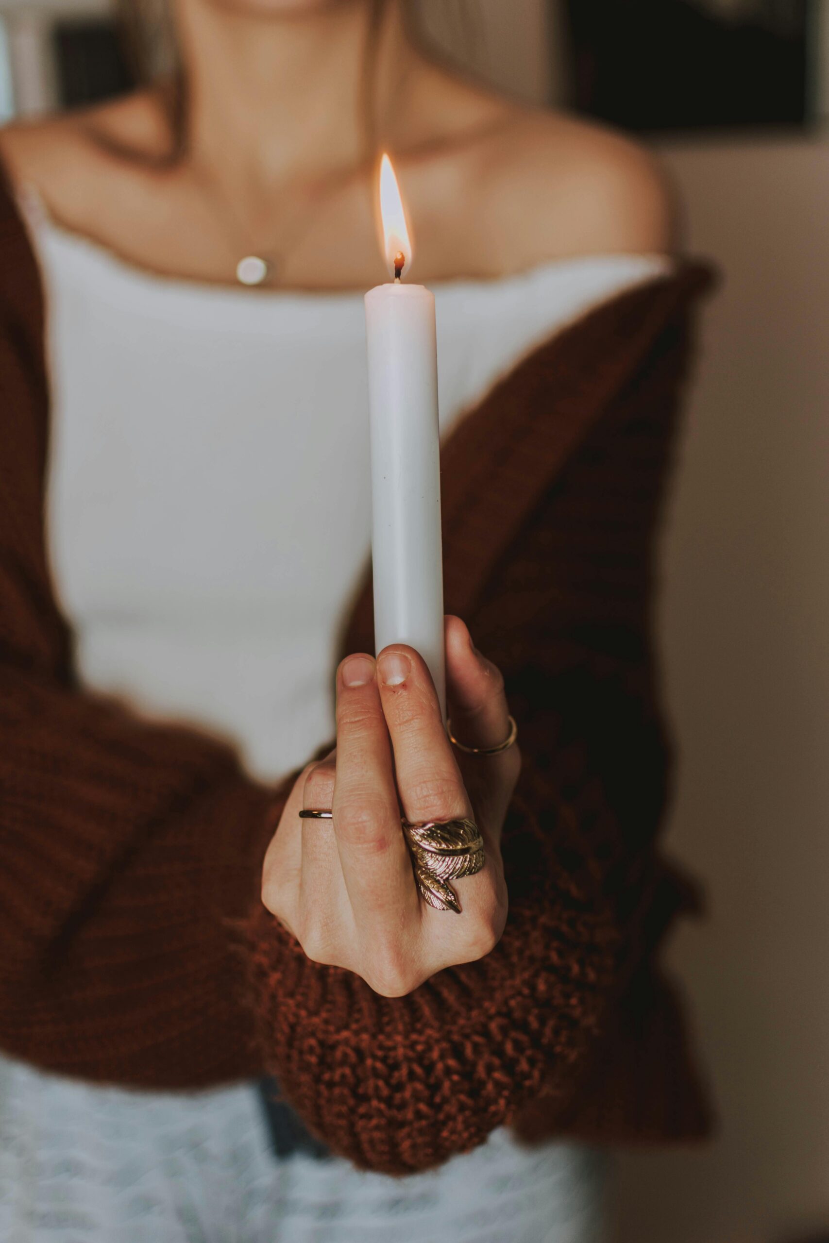 Femme tenant une bougie allumée dans une ambiance apaisante